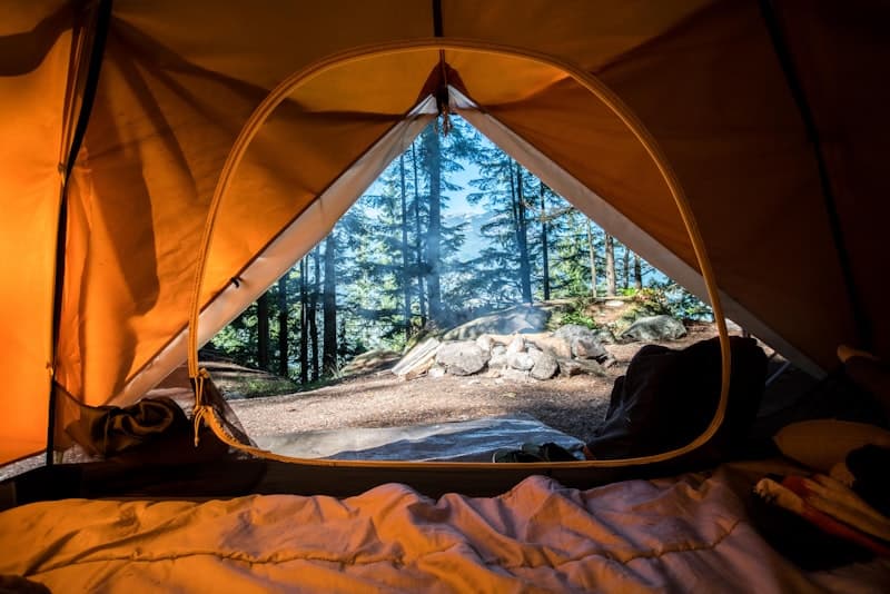 Tent camping on the beach at sunset with ocean in the background