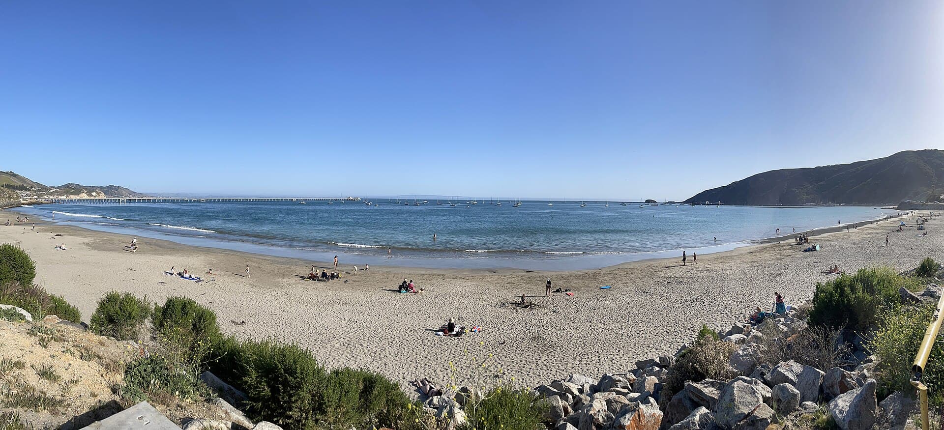 Panorama of San Luis Obispo Bay from the beach at Port San Luis, with Harford Pier on the right, the Cal Poly pier on the left and sailboats moored in between