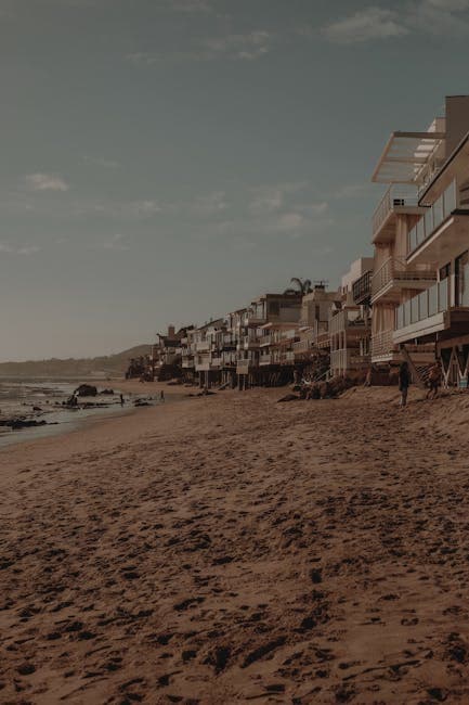 Malibu coastline with waves breaking along sandy beach and mountains in the distance