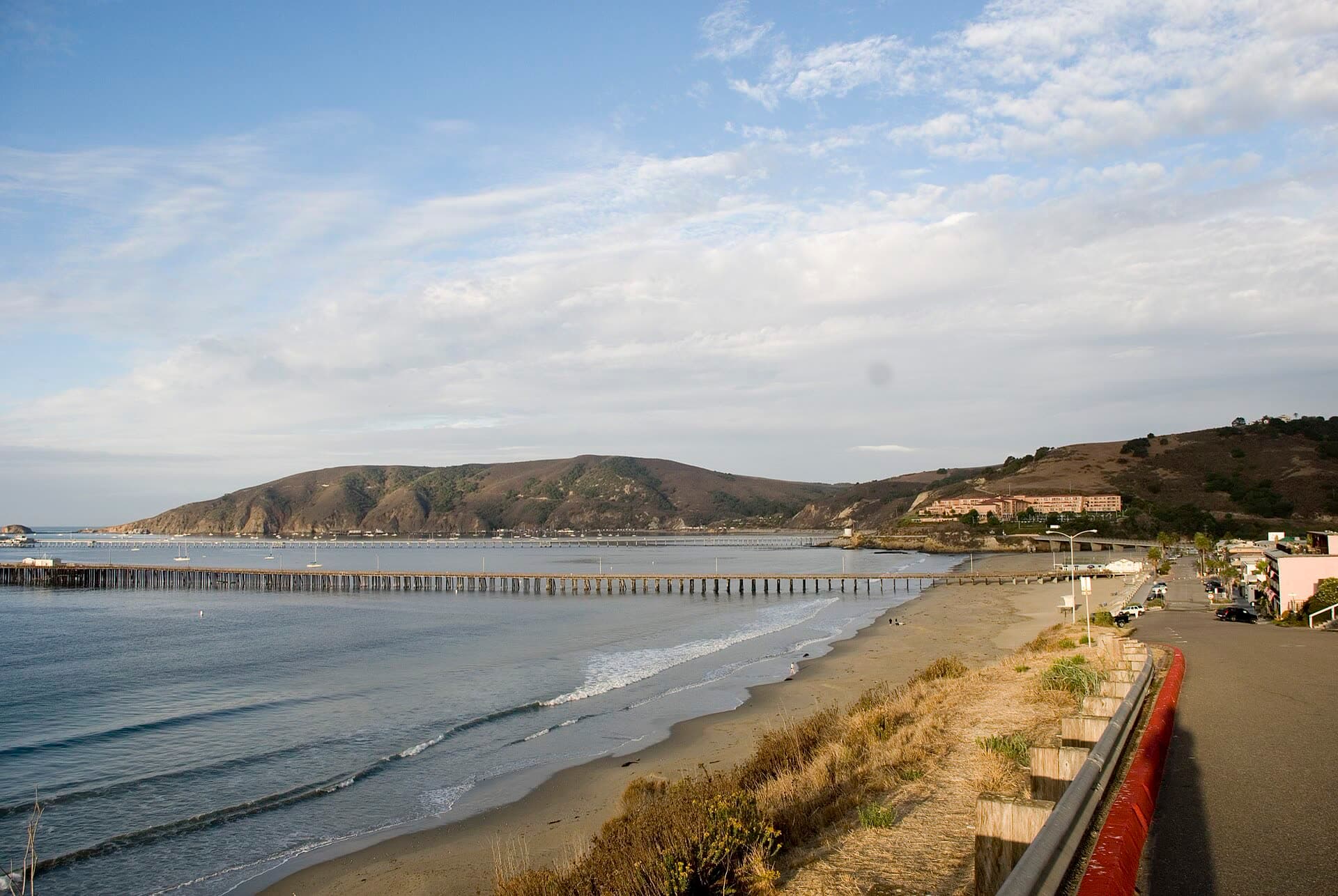 Morning view along Avila Beach from the end of Front Street, with the long pier reaching into the bay and the Port San Luis headland behind